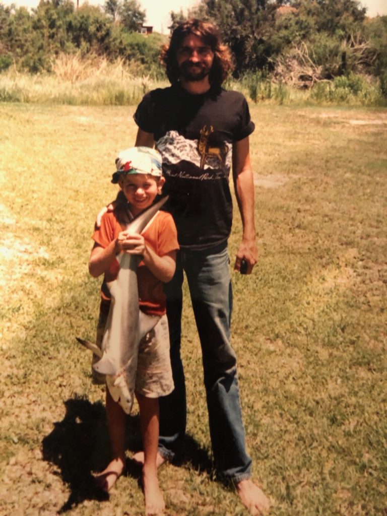 little boy holding shark with father