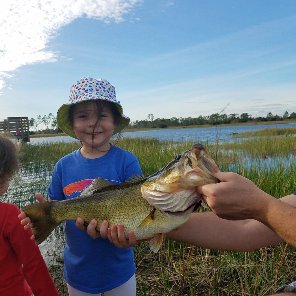 little girl with giant largemouth bass