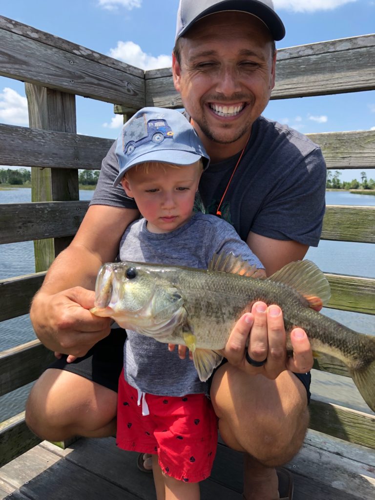 Dad with little boy and largemouth bass